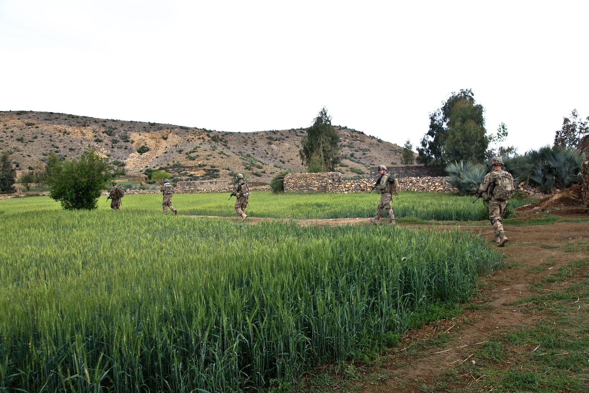 US Troops walking across an open field.